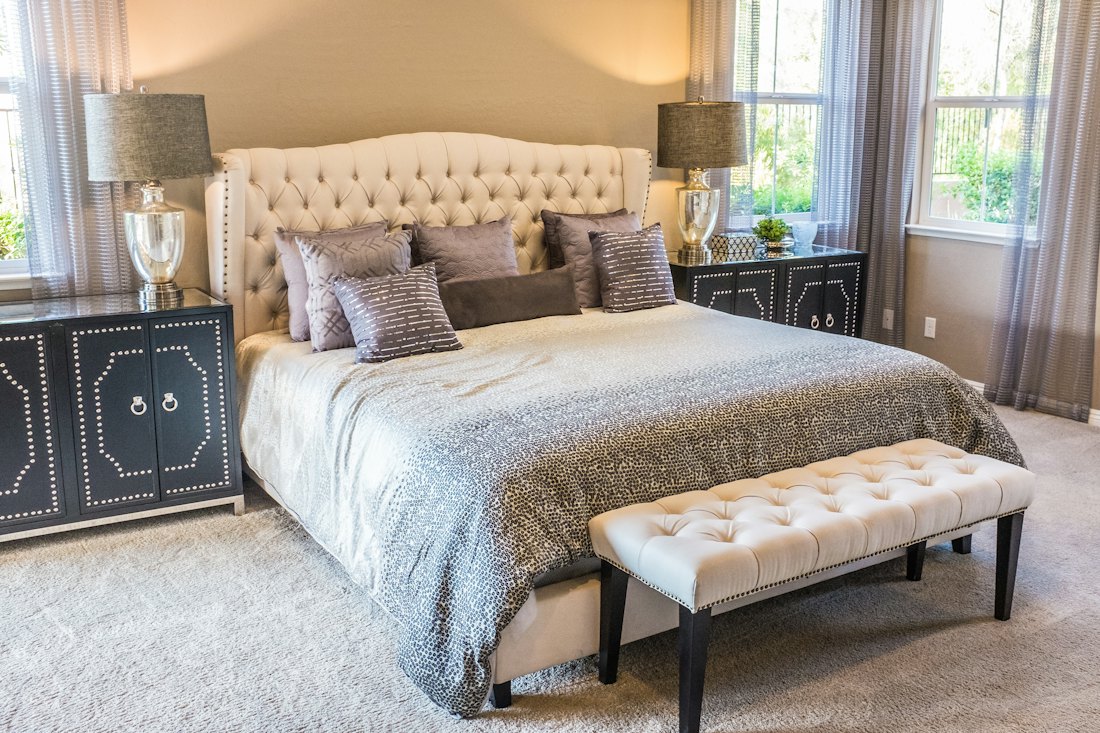 A calm bedroom with neatly made bed and soft linen