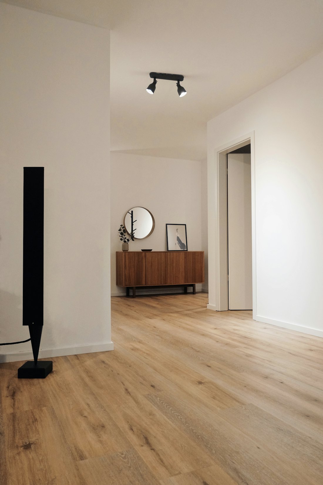 A bright, empty hallway with wooden floors